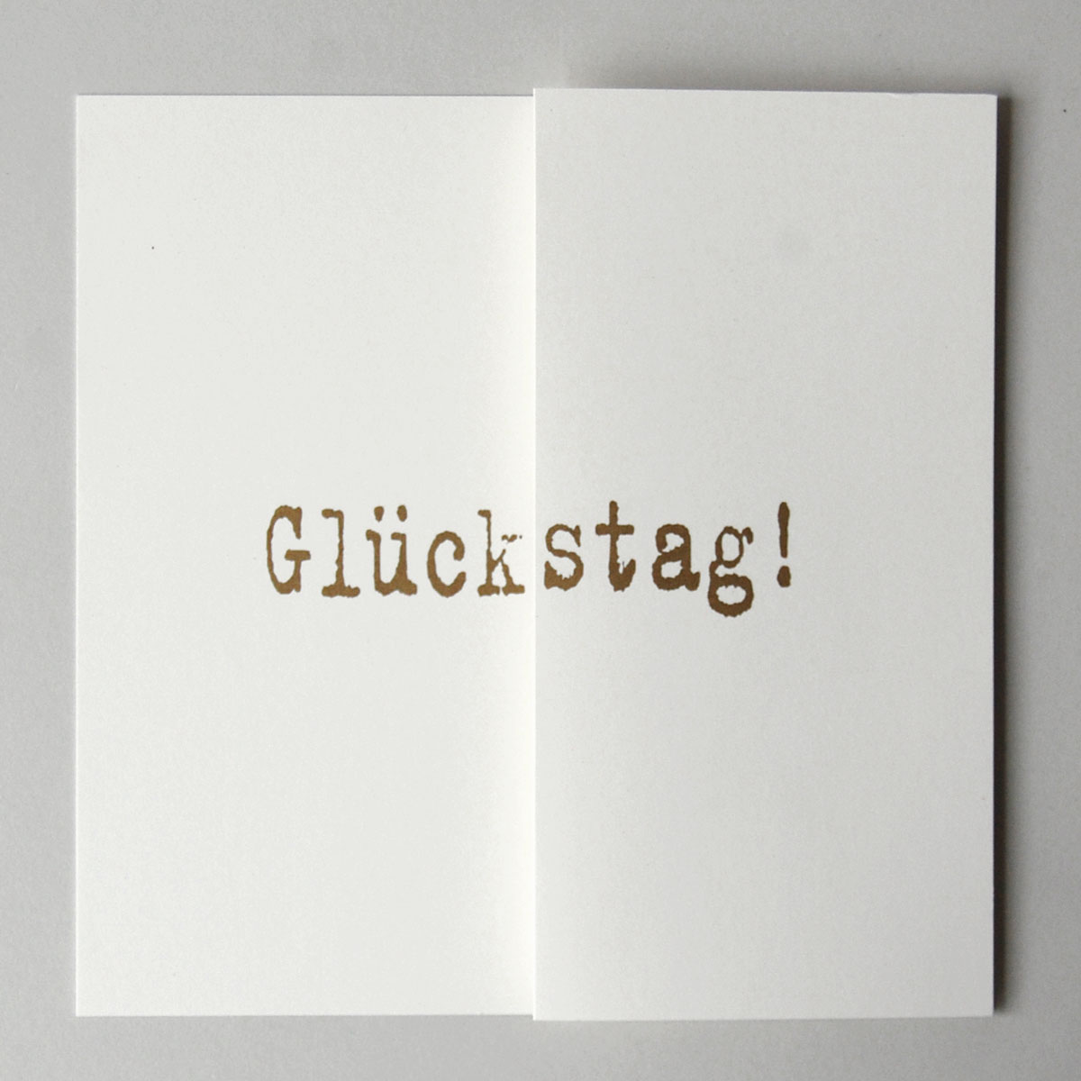 Glückwunschkarte zugeklappt mit dem gold gedruckten Text: Glückstag!