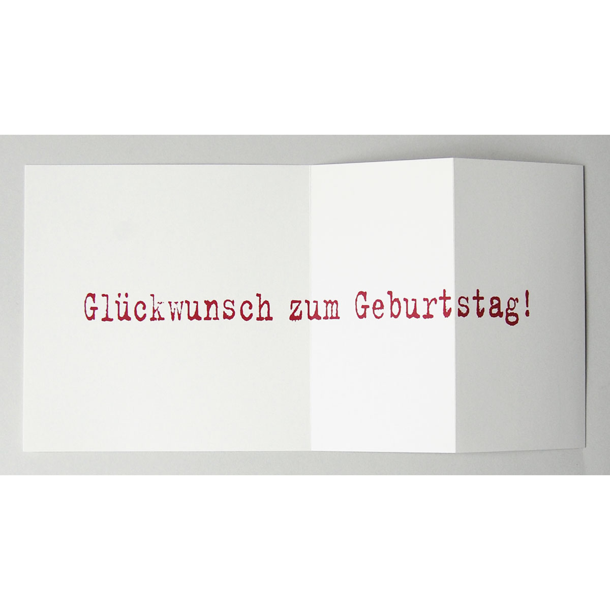 Glückwunschkarte aufgeklappt mit dem gedruckten Text: Glückwunsch zum Geburtstag!