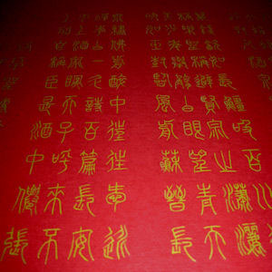Kalligraphie mit Goldfarbe auf rotem Papier, Siegelschrift