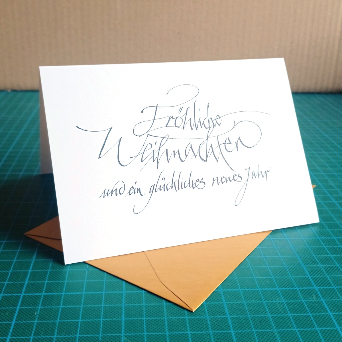 Weihnachtsgrüße mit Kalligrafie und goldenen Umschlägen