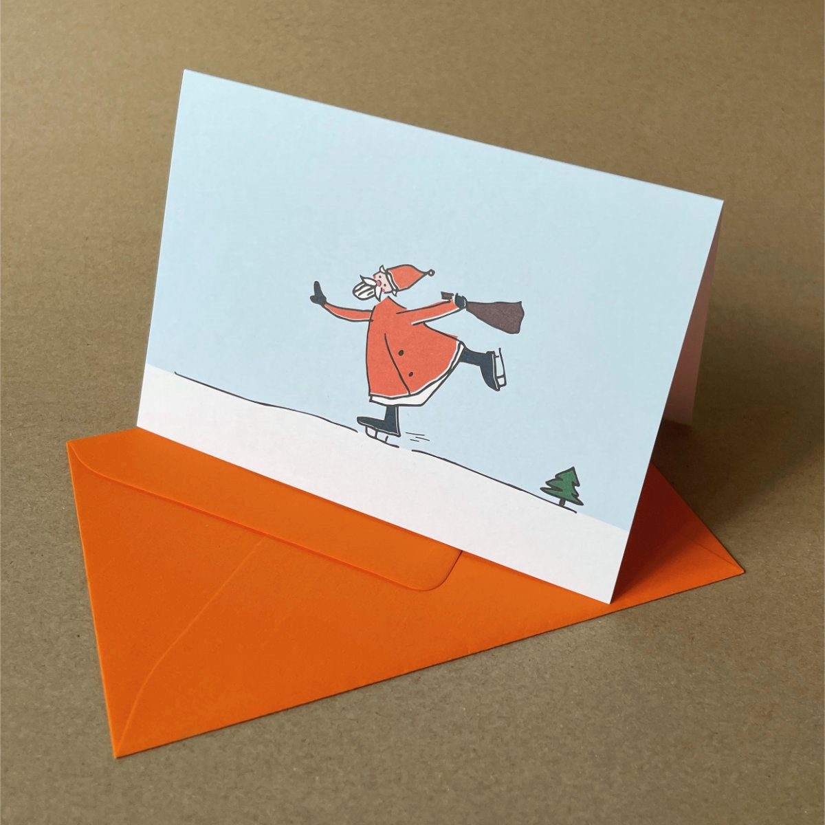 witzige Weihnachtskarten mit weißen Umschlägen: schlittschuhlaufender Weihnachtsmann