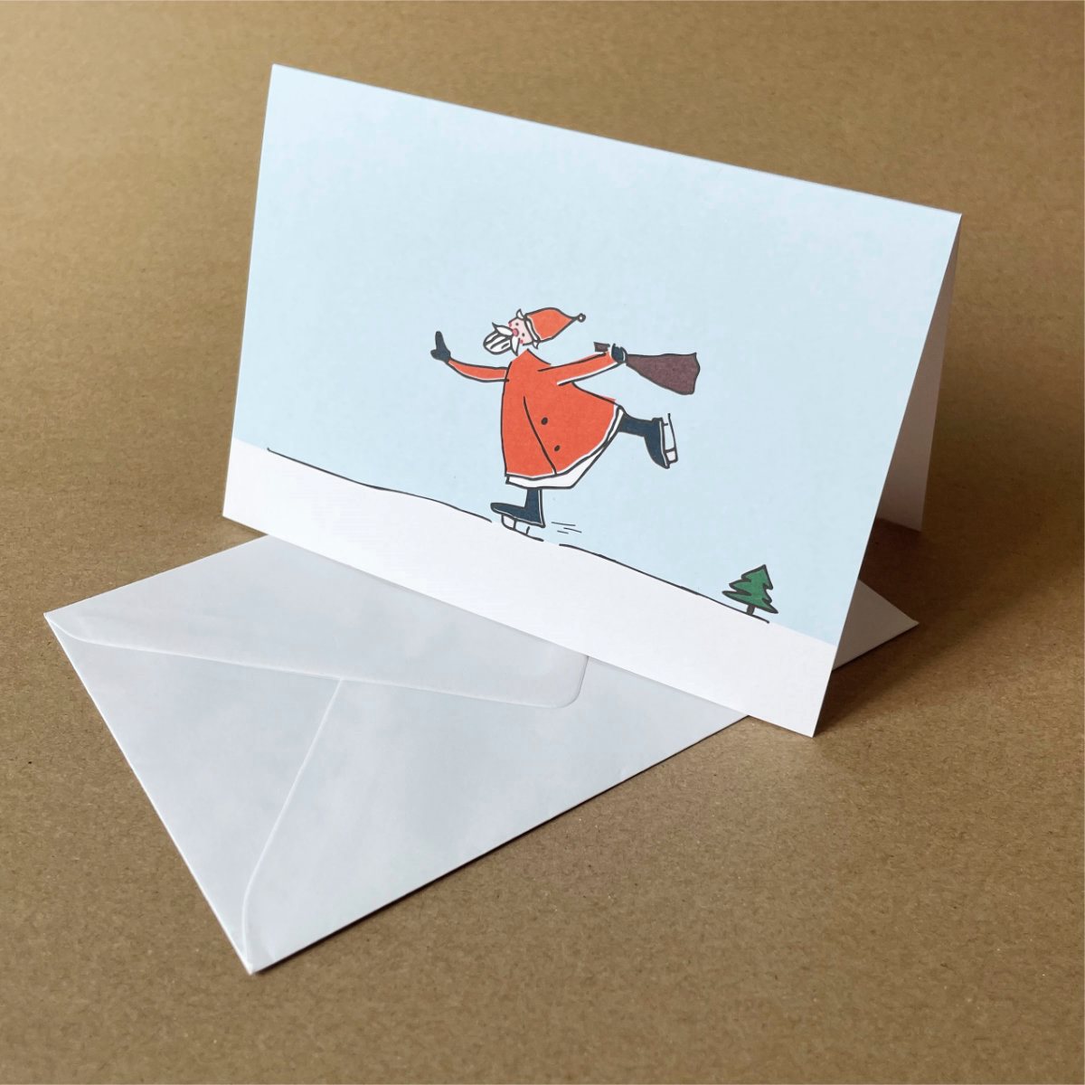 sportliche Weihnachtskarten mit weißen Umschlägen: schlittschuhlaufender Weihnachtsmann