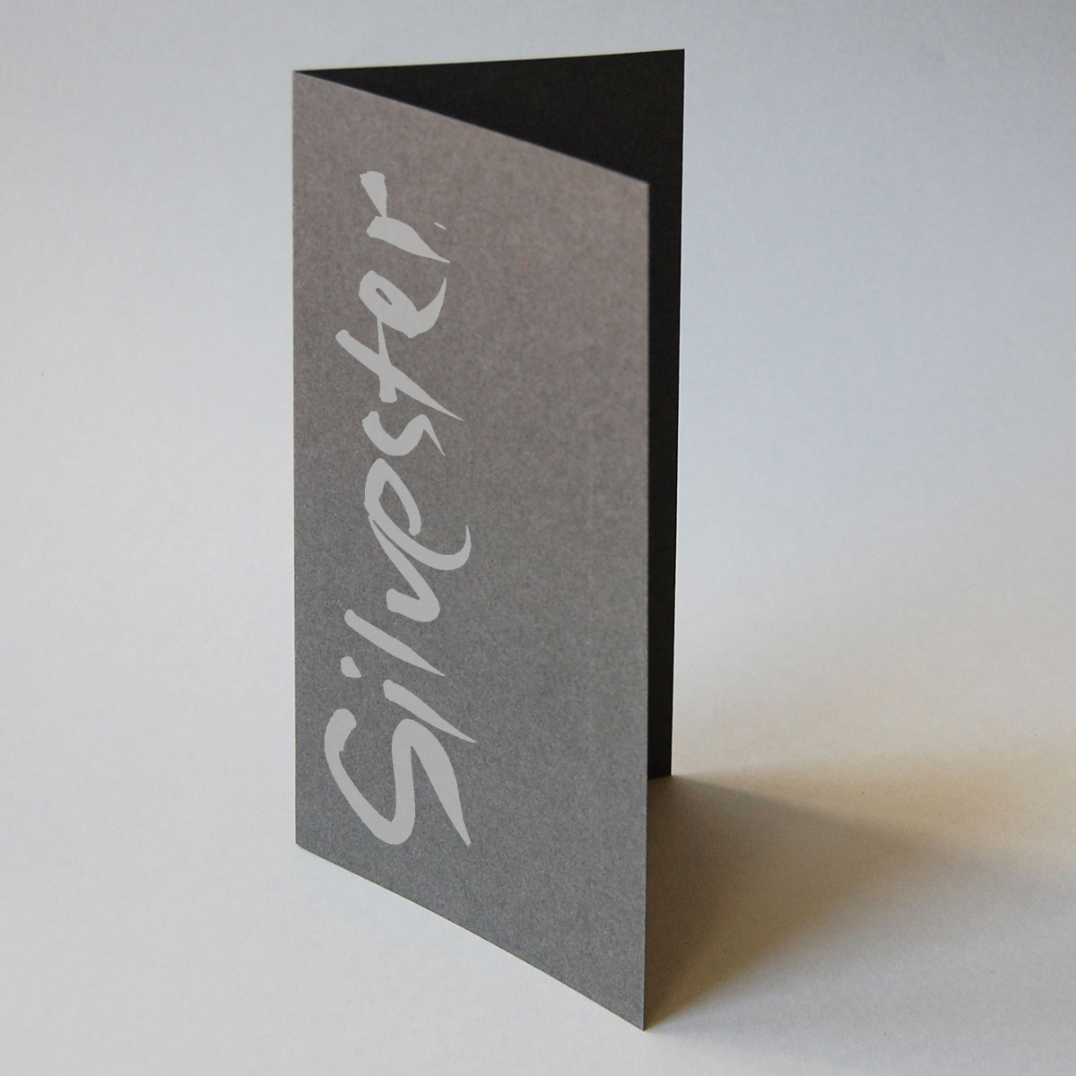 Silvester, Neujahrskarten mit schwungvoller Kalligrafie: silberner Druck auf grauem Karton