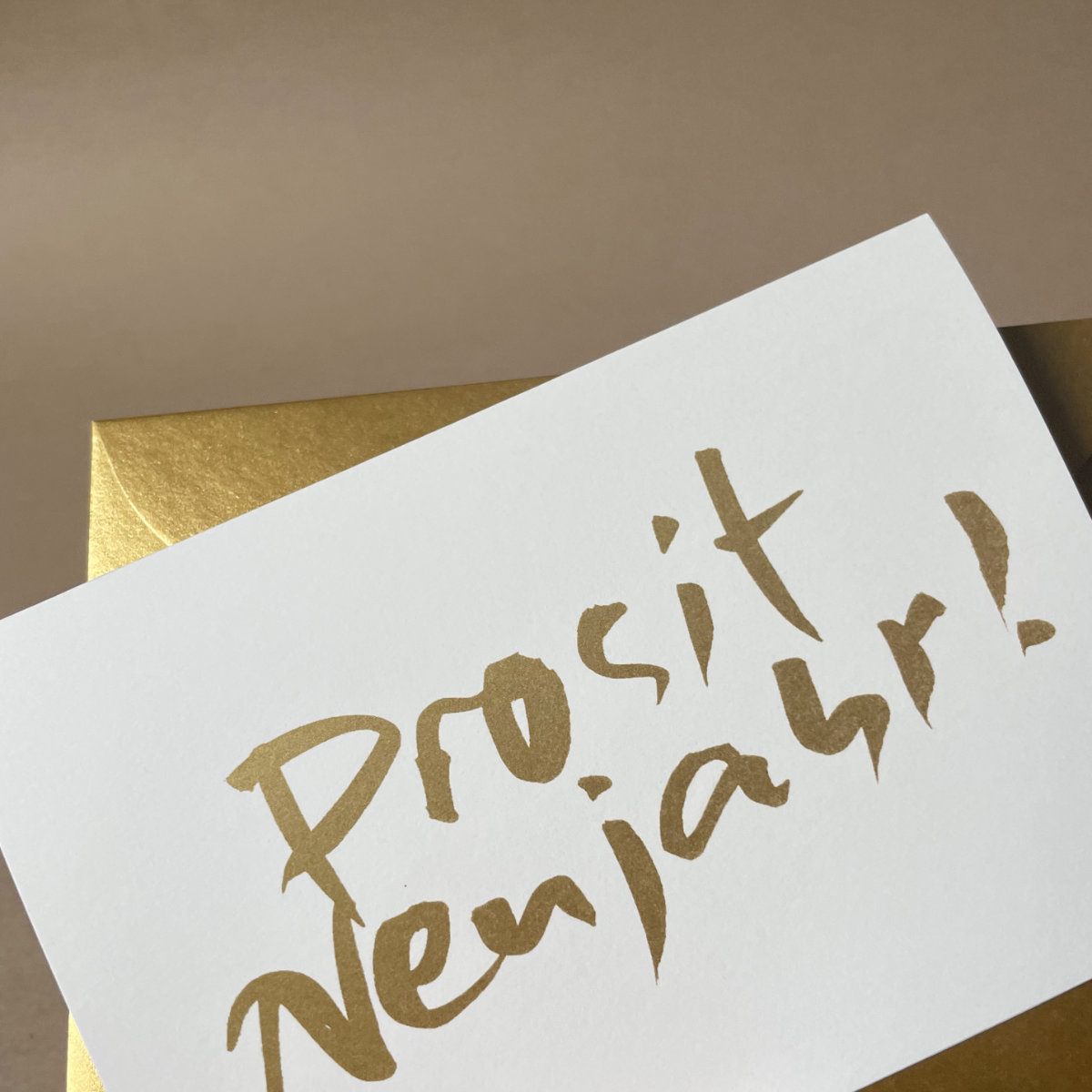 Neujahrskarten mit schwungvoller, goldener Kalligrafie und goldenem Umschlag