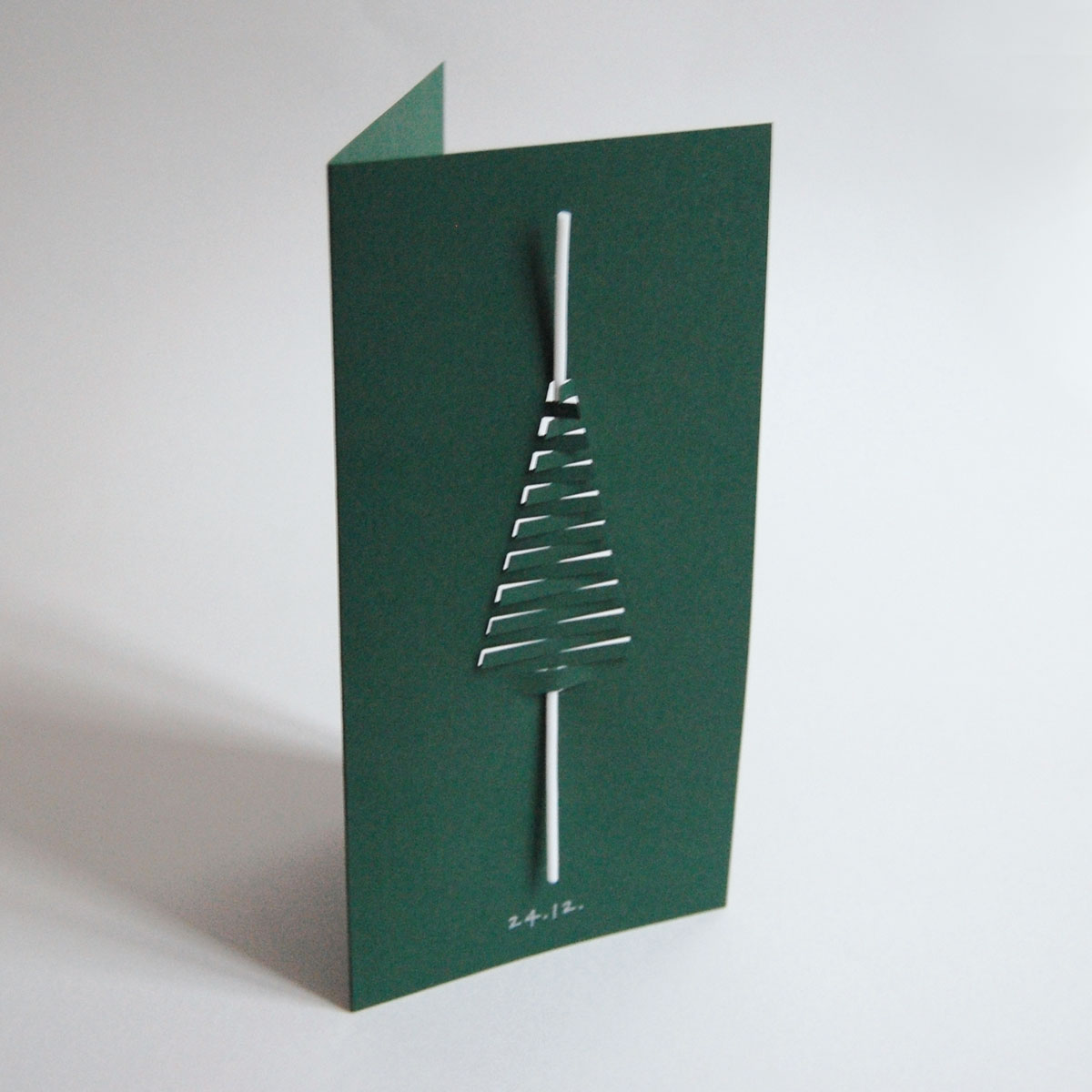 dunkelgrüne Design-Weihnachtskarte mit eingesteckter weißer Spaghettikerze