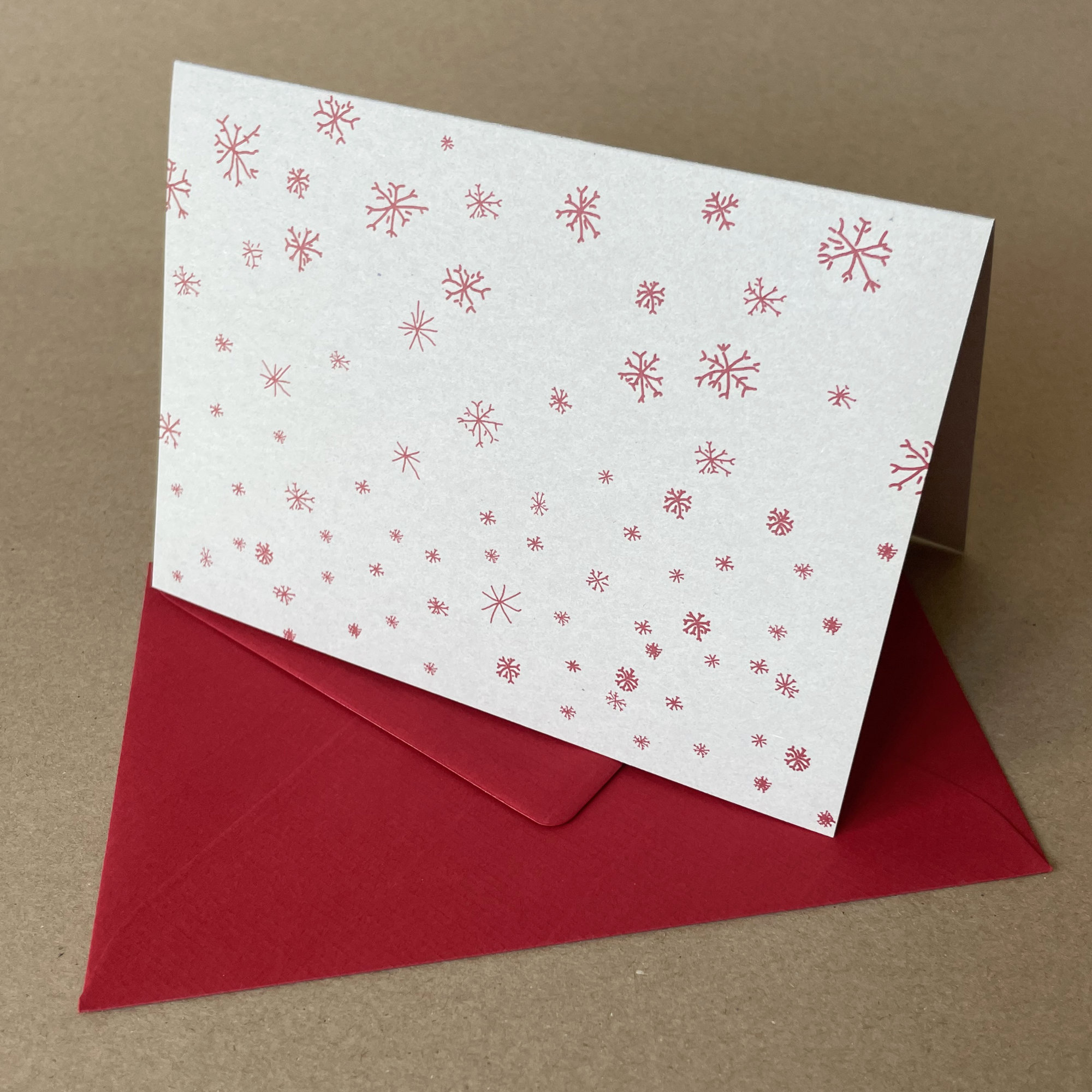 Schneeflocken, graue Recycling-Weihnachtskarten mit roten Schneeflocken und roten Kuverts