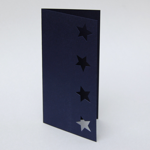 dunkelblaue, unbedruckte Weihnachtskarten mit gestanzten Sternen, Weihnachtskarte fotografiert aus einem leicht anderen Blickwinkel