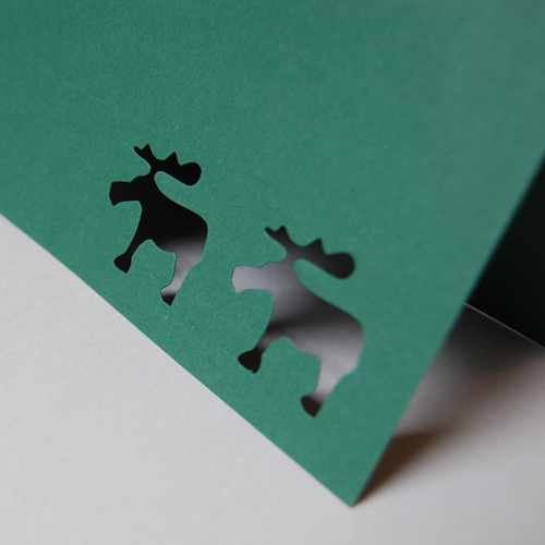 dunkelgrüne, monochrome Weihnachtskarte mit ausgestanzten Elchen
