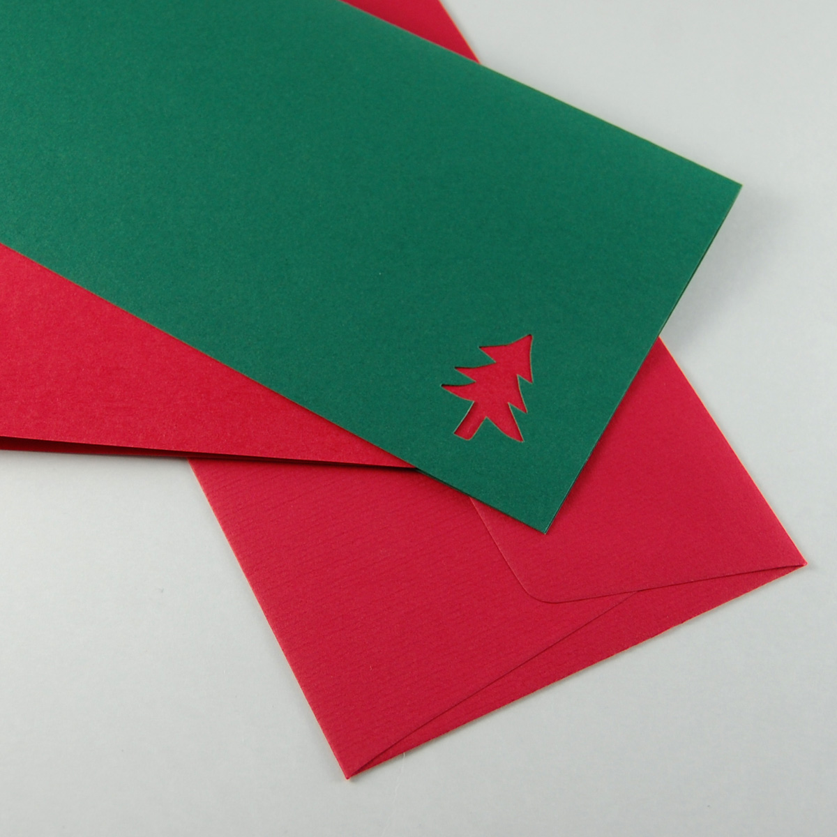 dunkelgrüne Weihnachtskarte mit roten Einlegeblättern und rotem Umschlag