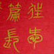 Chinesische Kalligraphie mit Goldfarbe auf rotem Papier