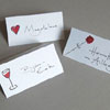 Tischdekoration für die Hochzeit: handgeschriebene Tischkarten mit einer roten Rose